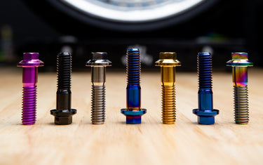 Premium titanium 3-piece wheel hardware bolts installed on a modular performance wheel